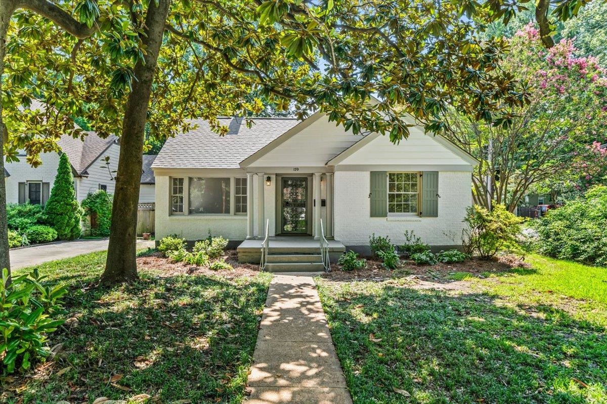 170 South Greer Street Memphis, TN 38111 - Photo 22 of 35 White stucco exterior with a gray-shingled roof, featuring a concrete walkway leading to the front entry