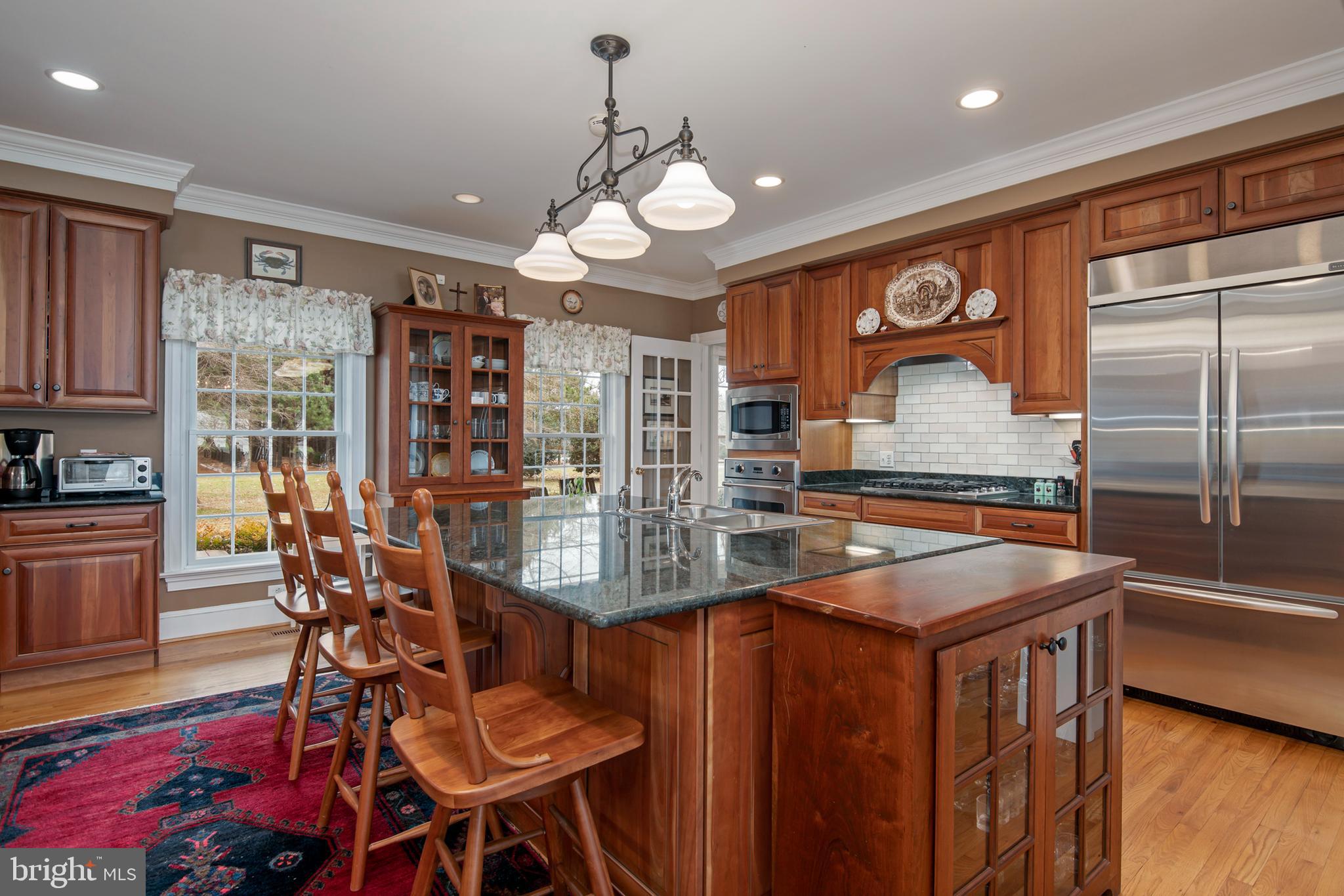 8781 Tilghman Island Road Wittman, MD 21676 - Photo 20 of 60 a kitchen with stainless steel appliances a table chairs and chandelier