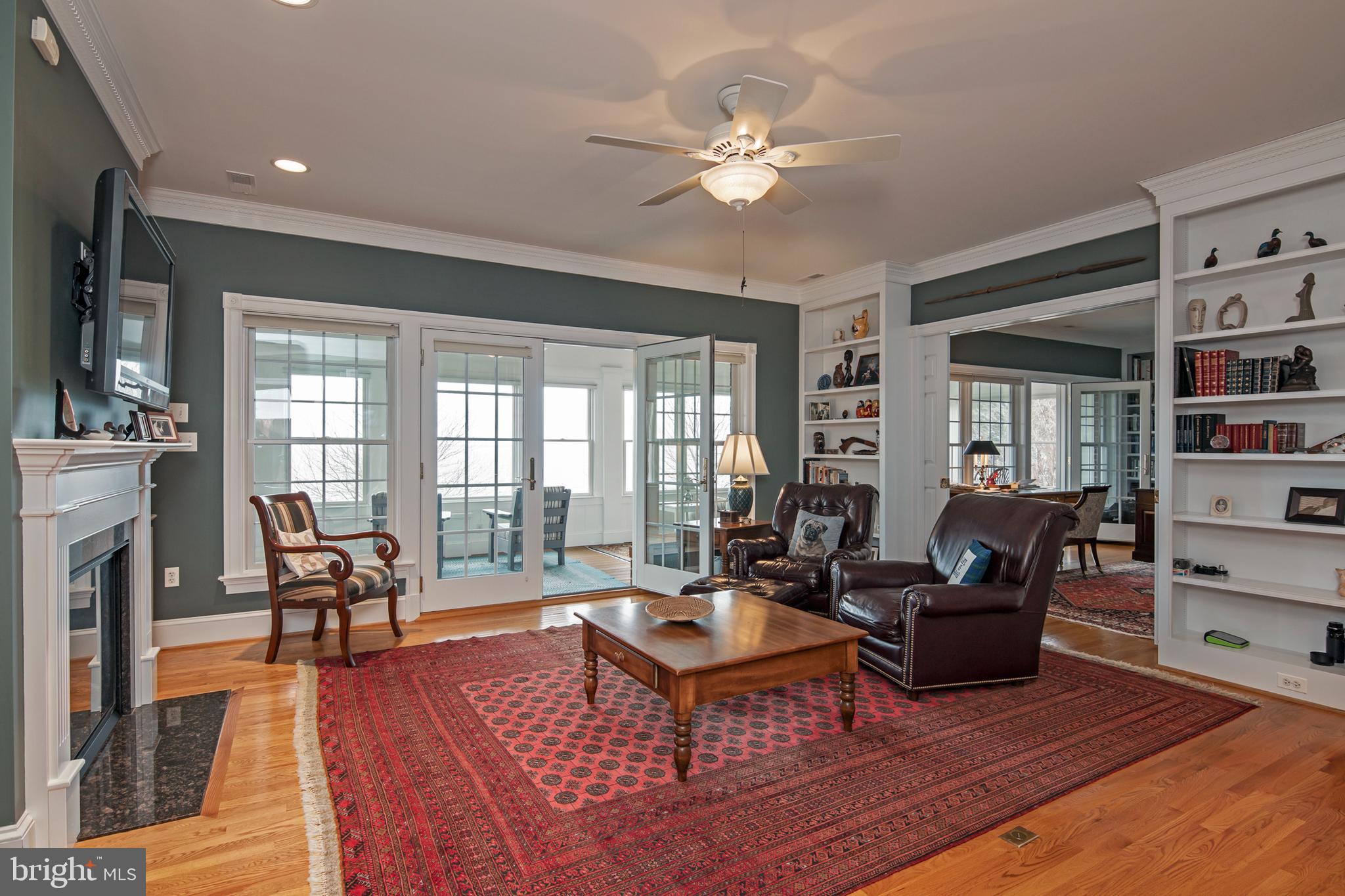 8781 Tilghman Island Road Wittman, MD 21676 - Photo 28 of 60 a living room with fireplace furniture and a wooden floor