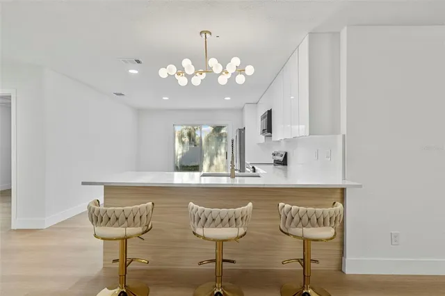 a kitchen with a sink cabinets and a chandelier