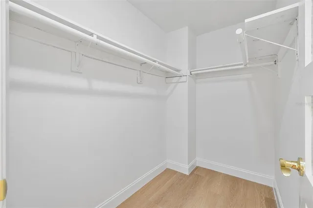 a view of a big room with wooden floor and windows