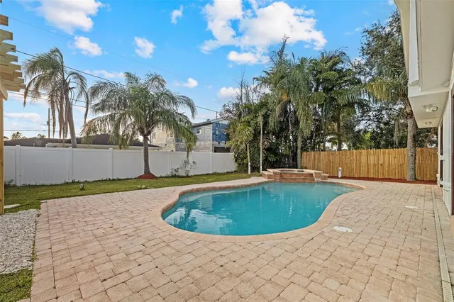 a view of a house with pool and sitting area