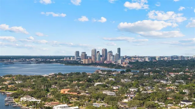 an empty room with wooden floor mirror and windows