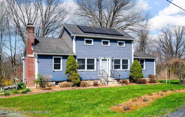 a front view of a house with a yard and outdoor seating