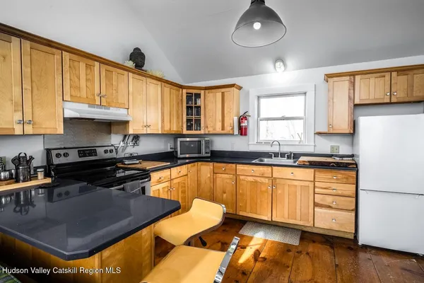 a kitchen with stainless steel appliances granite countertop a sink dishwasher stove and cabinets with wooden floor