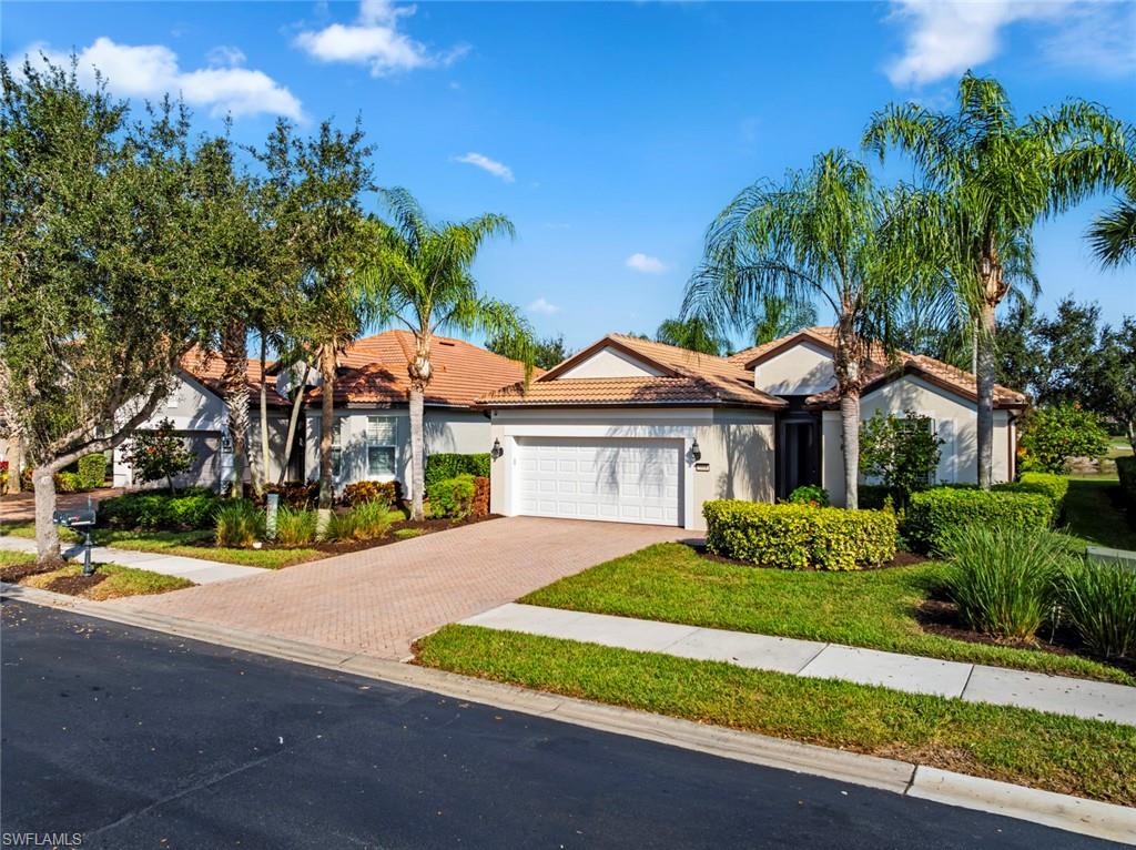 5868 Constitution Street Ave Maria, FL 34142 - Photo 1 of 33 a front view of a house with a yard and potted plants