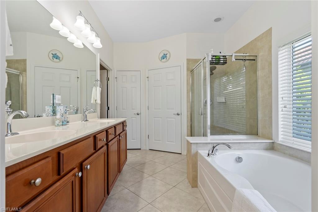 5868 Constitution Street Ave Maria, FL 34142 - Photo 15 of 33 a spacious bathroom with a tub sink shower and mirror