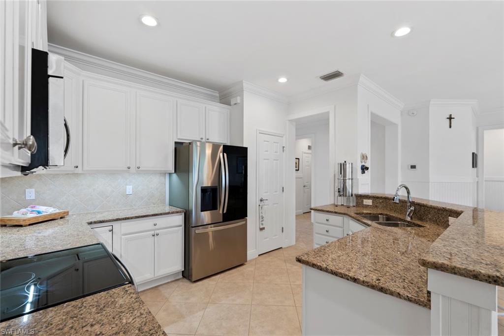 5868 Constitution Street Ave Maria, FL 34142 - Photo 8 of 33 a kitchen with stainless steel appliances granite countertop a sink stove and refrigerator