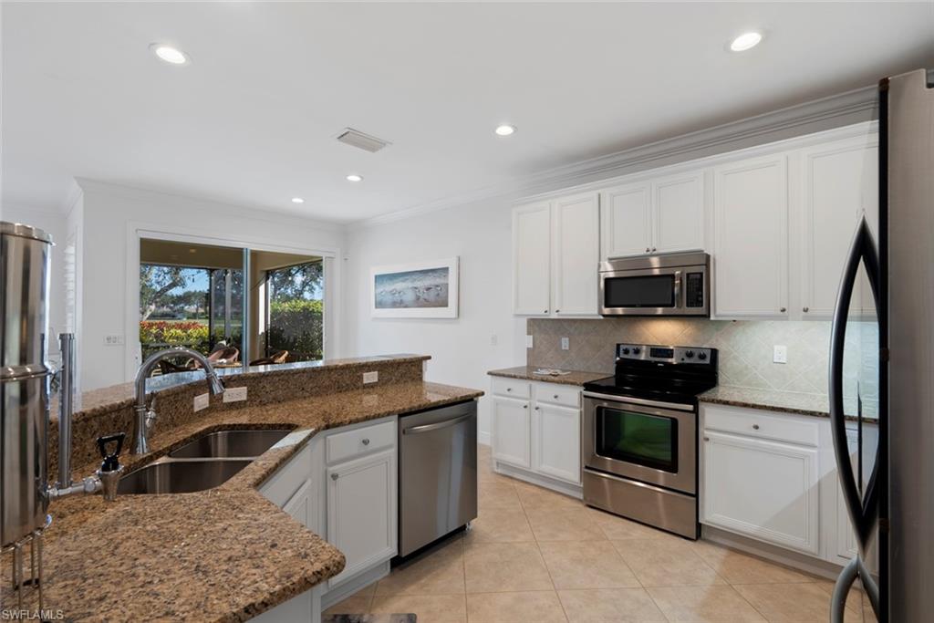 5868 Constitution Street Ave Maria, FL 34142 - Photo 10 of 33 a kitchen with stainless steel appliances granite countertop a sink stove and refrigerator
