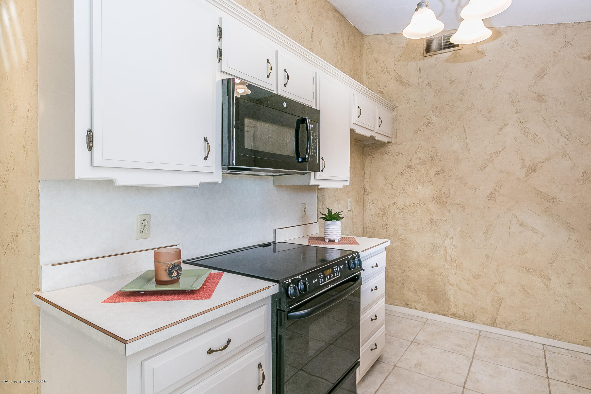 4609 Journey Street Amarillo, TX 79110 - Photo 8 of 30 a kitchen with stainless steel appliances white cabinets and a stove top oven