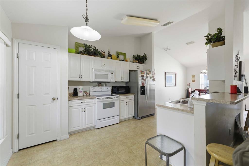 3959 Southwest 129th Street Ocala, FL 34473 - Photo 4 of 27 a kitchen with white cabinets and white appliances