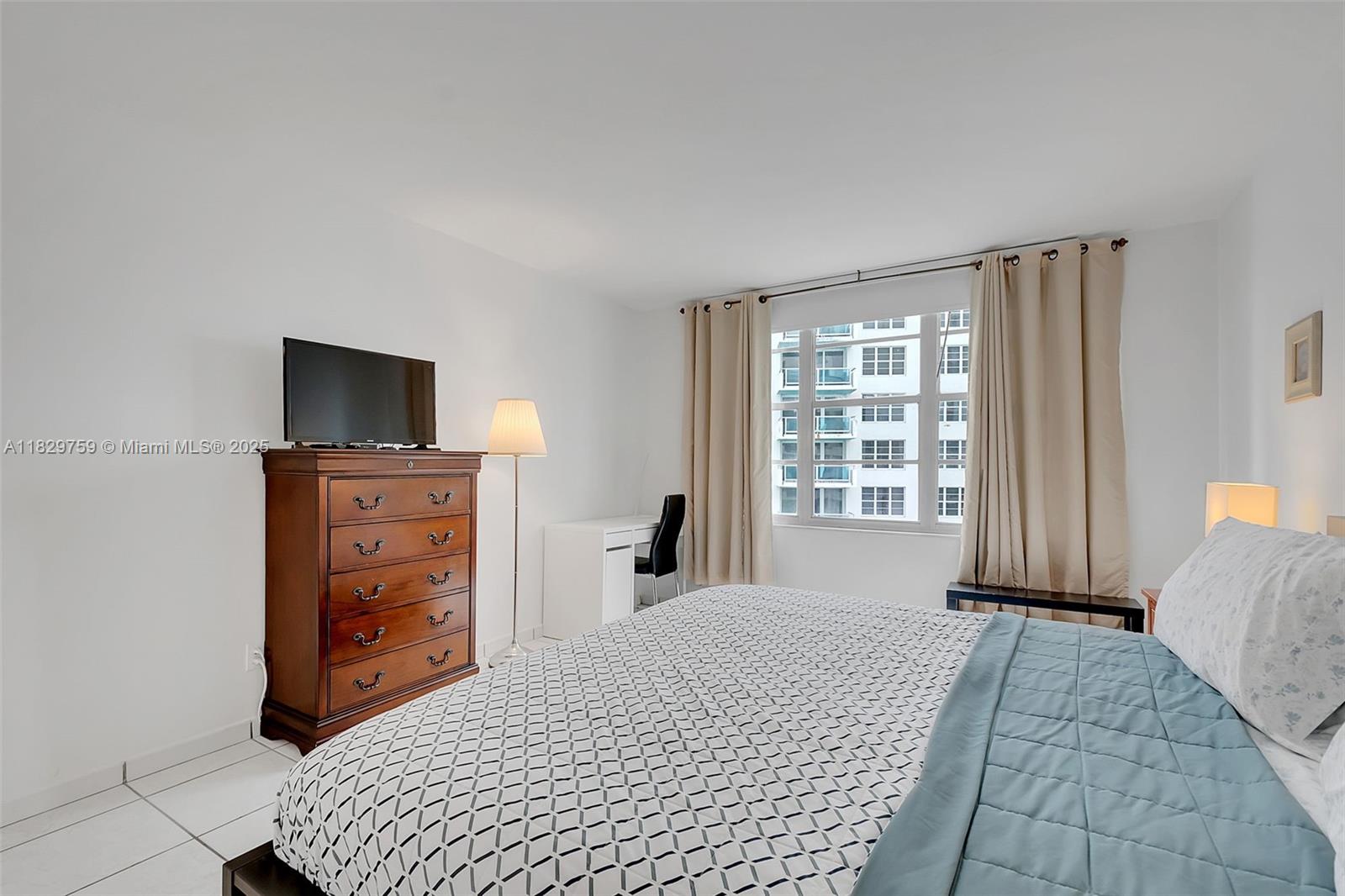 5151 Collins Avenue, Unit 729 Miami Beach, FL 33140 - Photo 11 of 35 a bedroom with a bed and a television