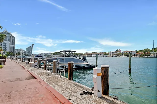 a view of a tall building next to a road with a palm trees