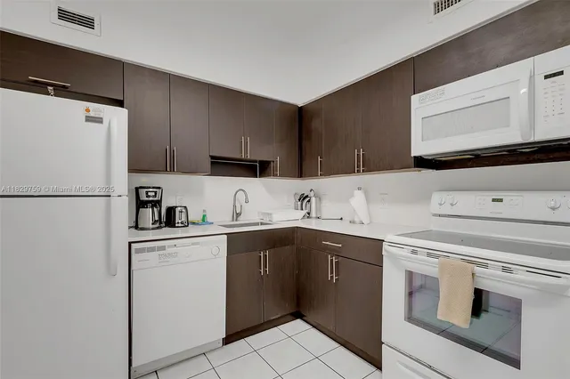 a kitchen with cabinets appliances a sink and a counter top space
