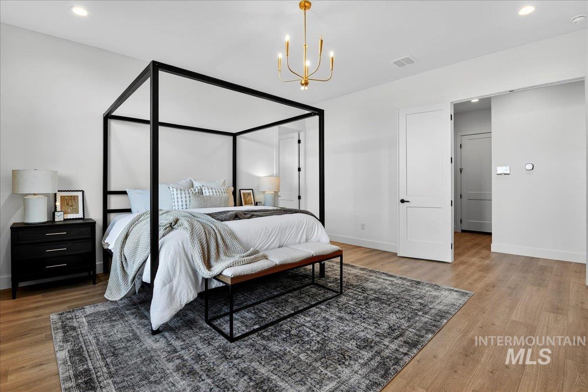 7714 West Flathead Lake Street, Unit ASPEN Eagle, ID 83616 - Photo 16 of 30 Bedroom featuring recessed lighting, a chandelier, and light wood finished floors