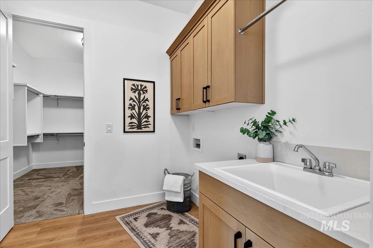 7714 West Flathead Lake Street, Unit ASPEN Eagle, ID 83616 - Photo 27 of 30 Washroom with hookup for a washing machine, light wood finished floors, cabinet space, and hookup for an electric dryer