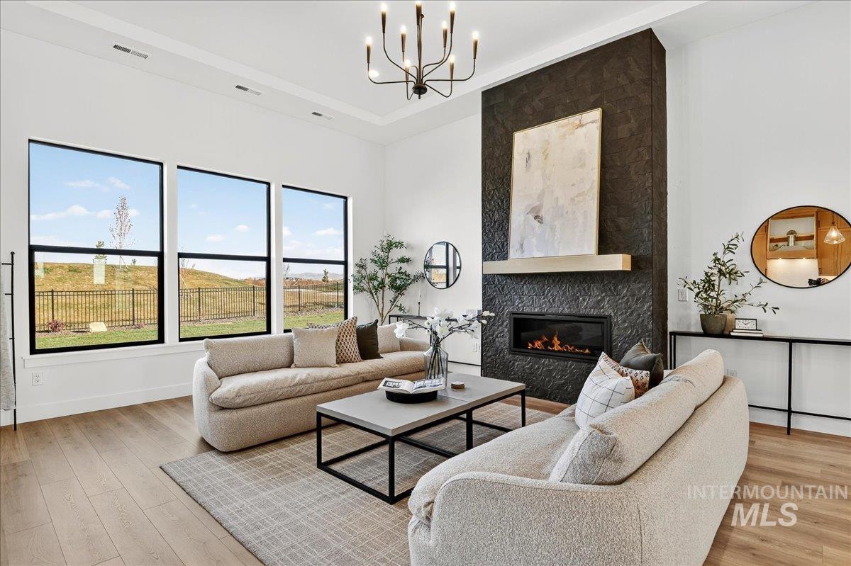 7714 West Flathead Lake Street, Unit ASPEN Eagle, ID 83616 - Photo 7 of 30 Living area with a high end fireplace, light wood-style flooring, and a chandelier