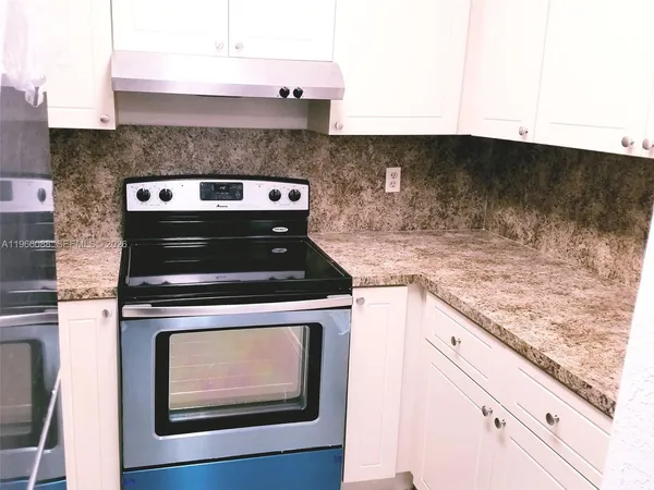 a stove top oven sitting inside of a kitchen