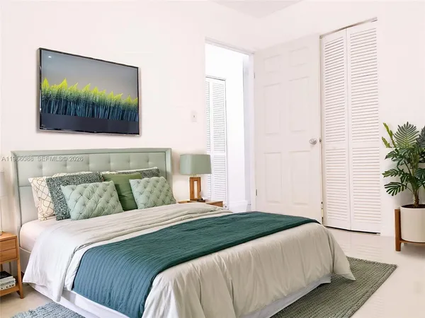 a bedroom with a bed and a potted plant