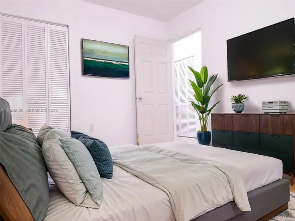 a bedroom with a bed and a flat screen tv