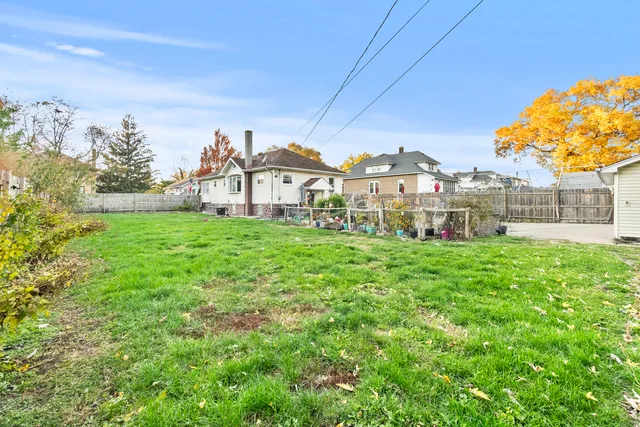 a view of a house with a big yard and large trees