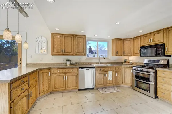 a kitchen with stainless steel appliances granite countertop a stove top oven a sink dishwasher and a microwave oven on the blue kitchen countertops
