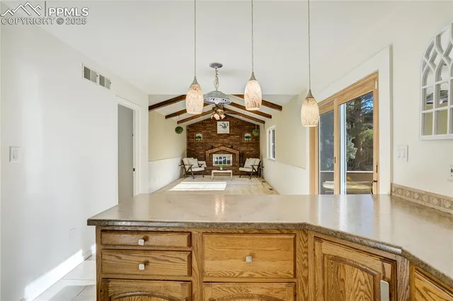 a view of a kitchen with kitchen island a sink wooden floor and living room view