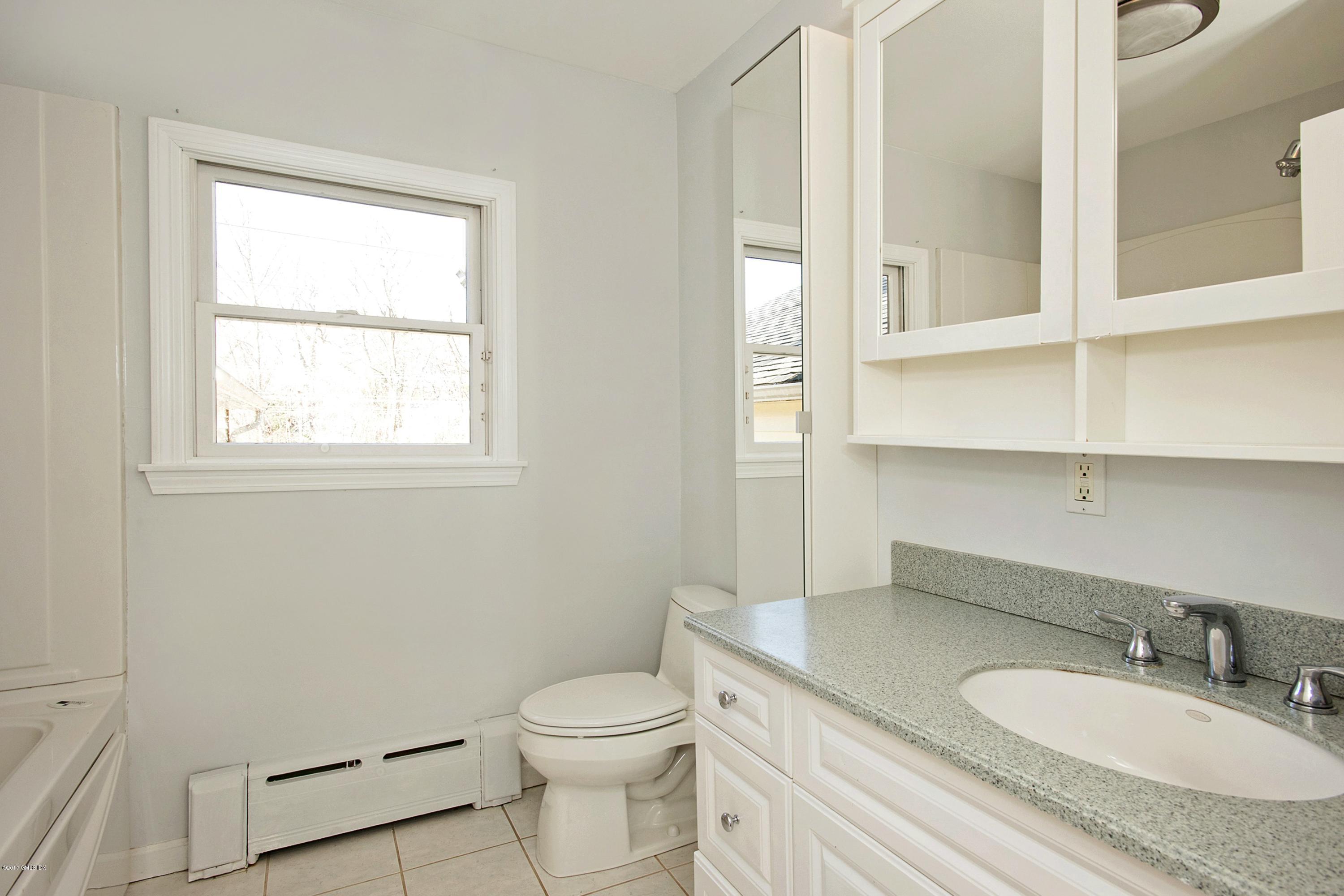 55 Oval Avenue Riverside, CT 06878 - Photo 13 of 19 a bathroom with a granite countertop toilet a sink and a mirror