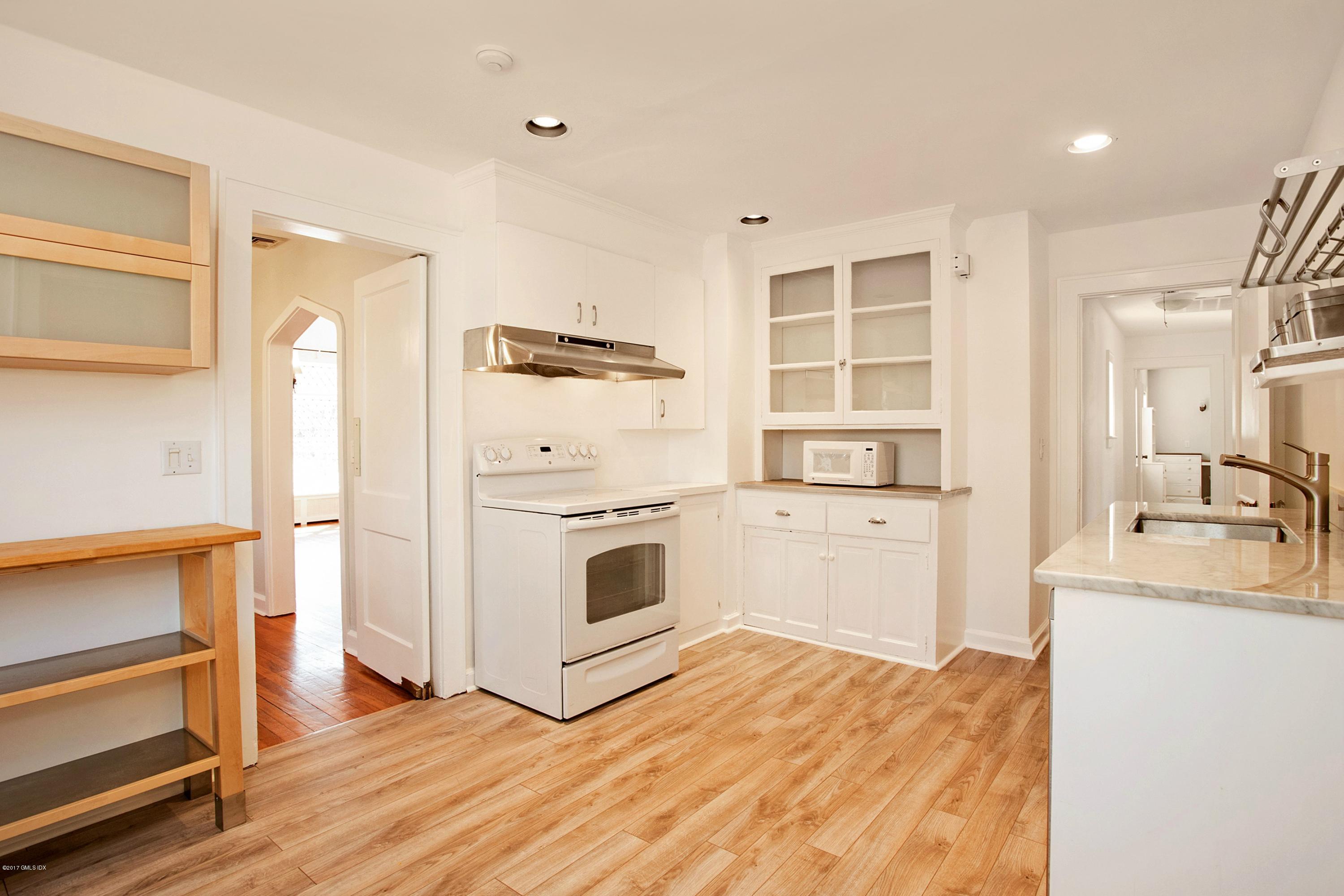 55 Oval Avenue Riverside, CT 06878 - Photo 9 of 19 a view of a kitchen with white cabinets and wooden floor