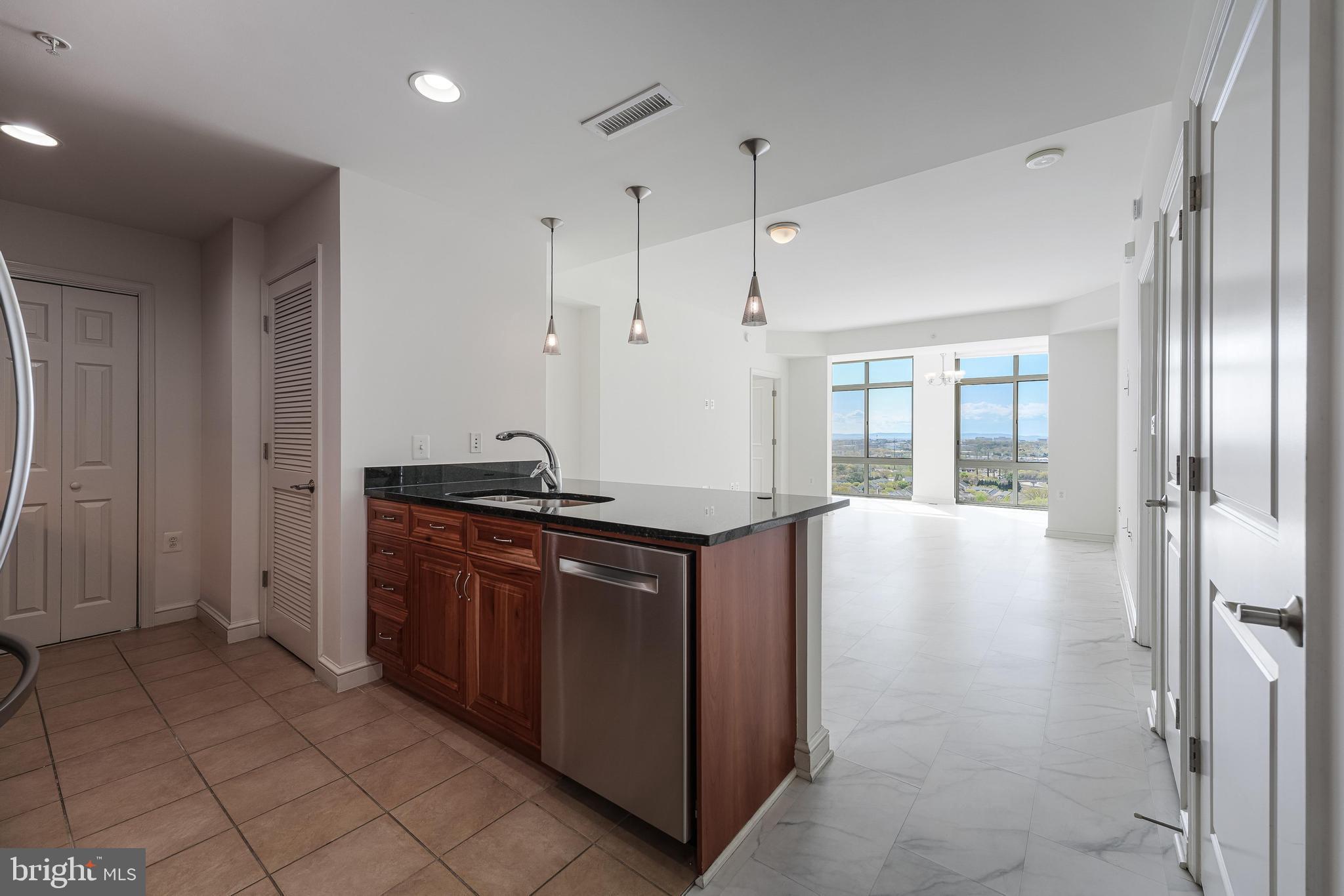 11990 Market Street, Unit 1414 Reston, VA 20190 - Photo 16 of 65 a kitchen with stainless steel appliances granite countertop a refrigerator and a sink