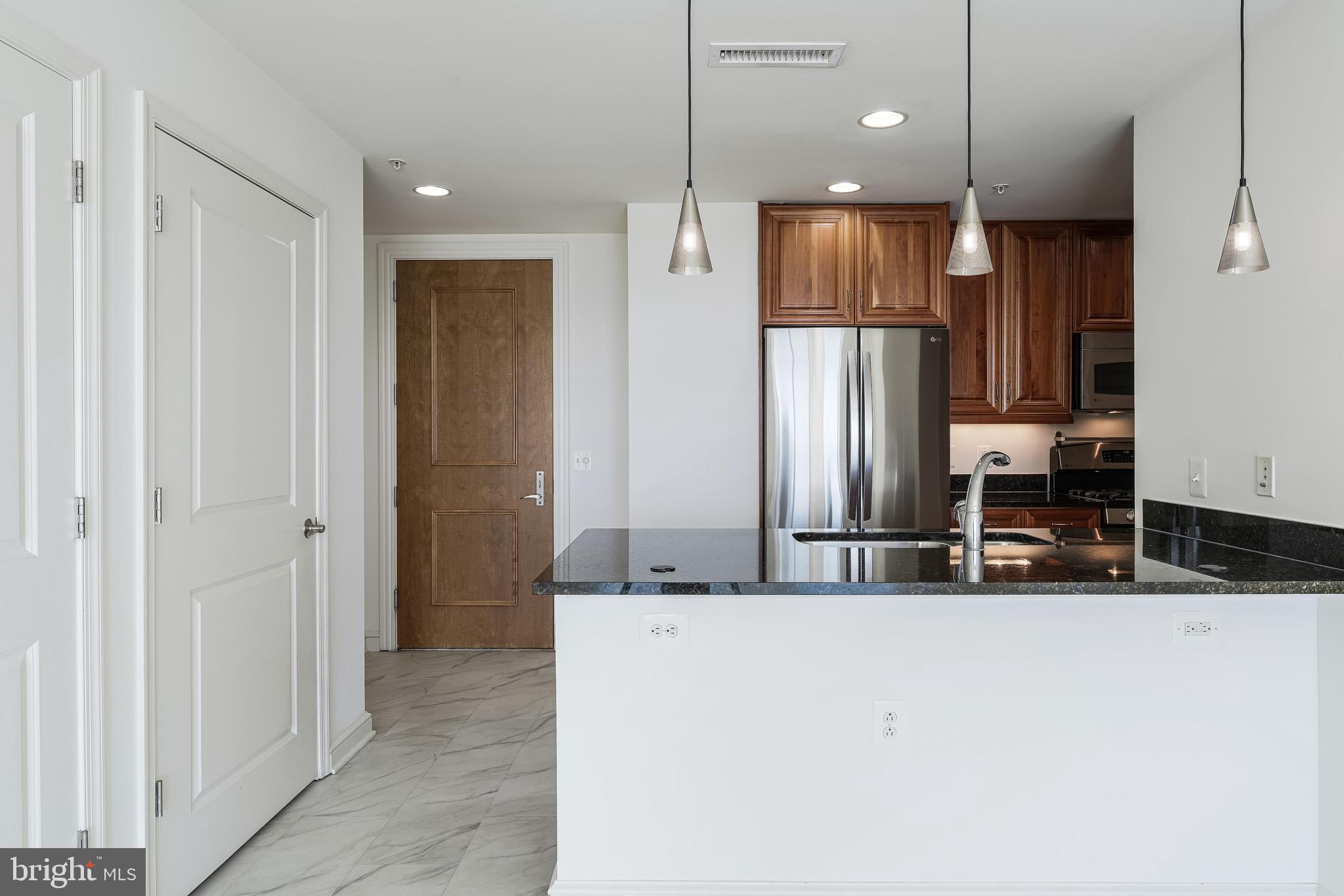 11990 Market Street, Unit 1414 Reston, VA 20190 - Photo 17 of 65 a kitchen with stainless steel appliances granite countertop a refrigerator and a sink