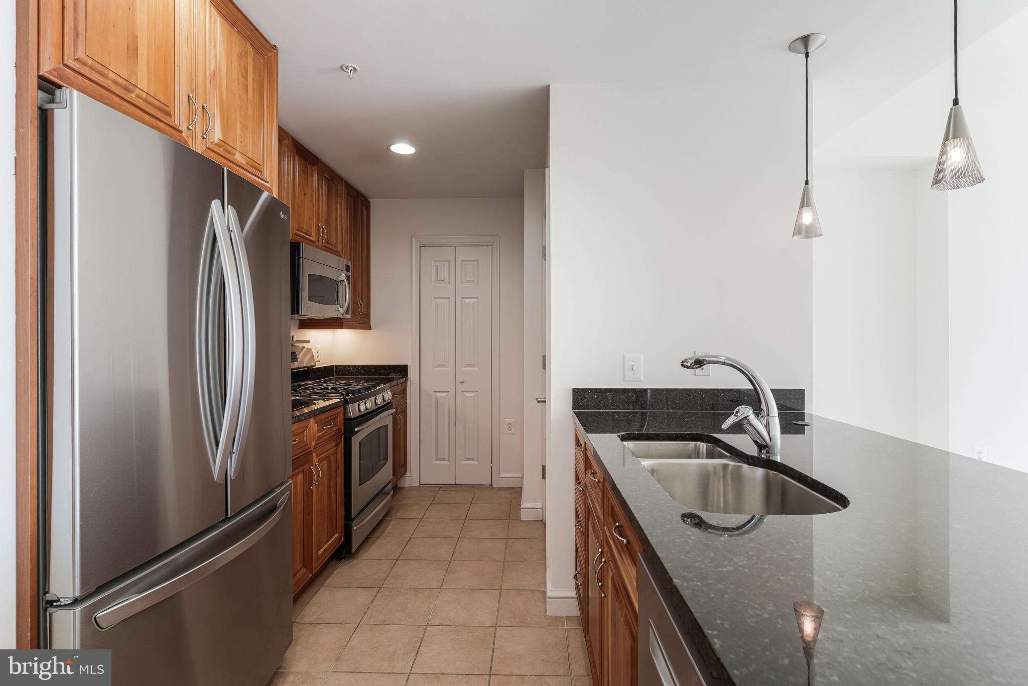 11990 Market Street, Unit 1414 Reston, VA 20190 - Photo 19 of 65 a kitchen with stainless steel appliances granite countertop a sink stove and refrigerator