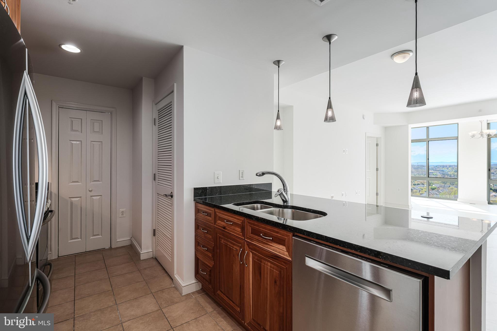 11990 Market Street, Unit 1414 Reston, VA 20190 - Photo 20 of 65 a kitchen with stainless steel appliances granite countertop a sink a refrigerator and a wooden floor