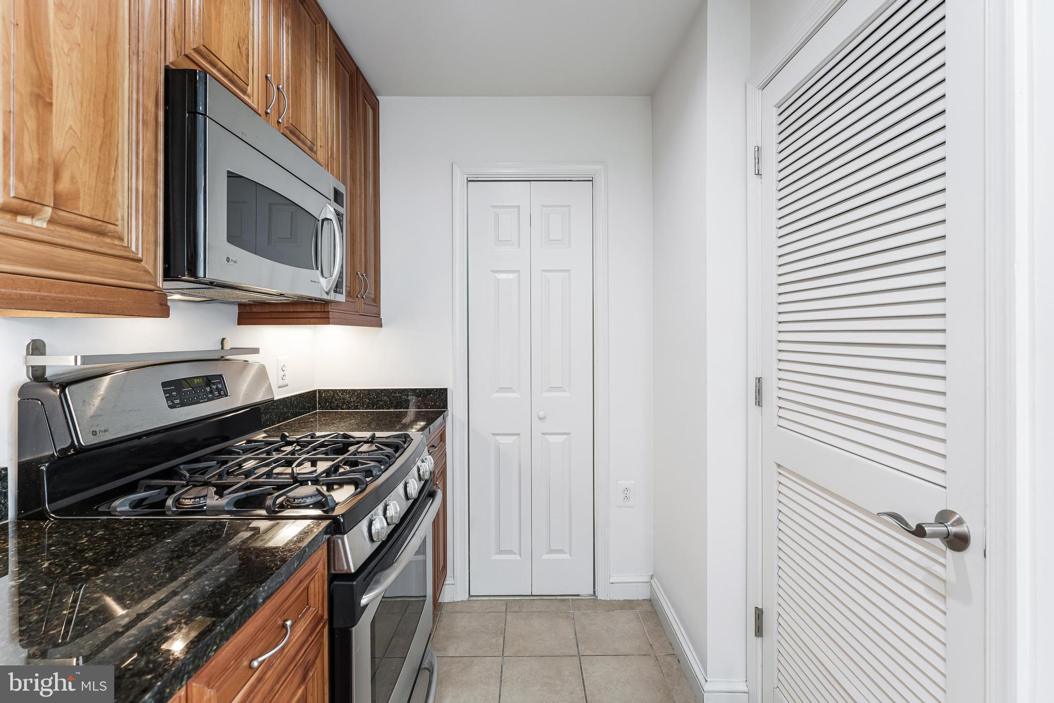 11990 Market Street, Unit 1414 Reston, VA 20190 - Photo 21 of 65 a kitchen with a stove and a microwave