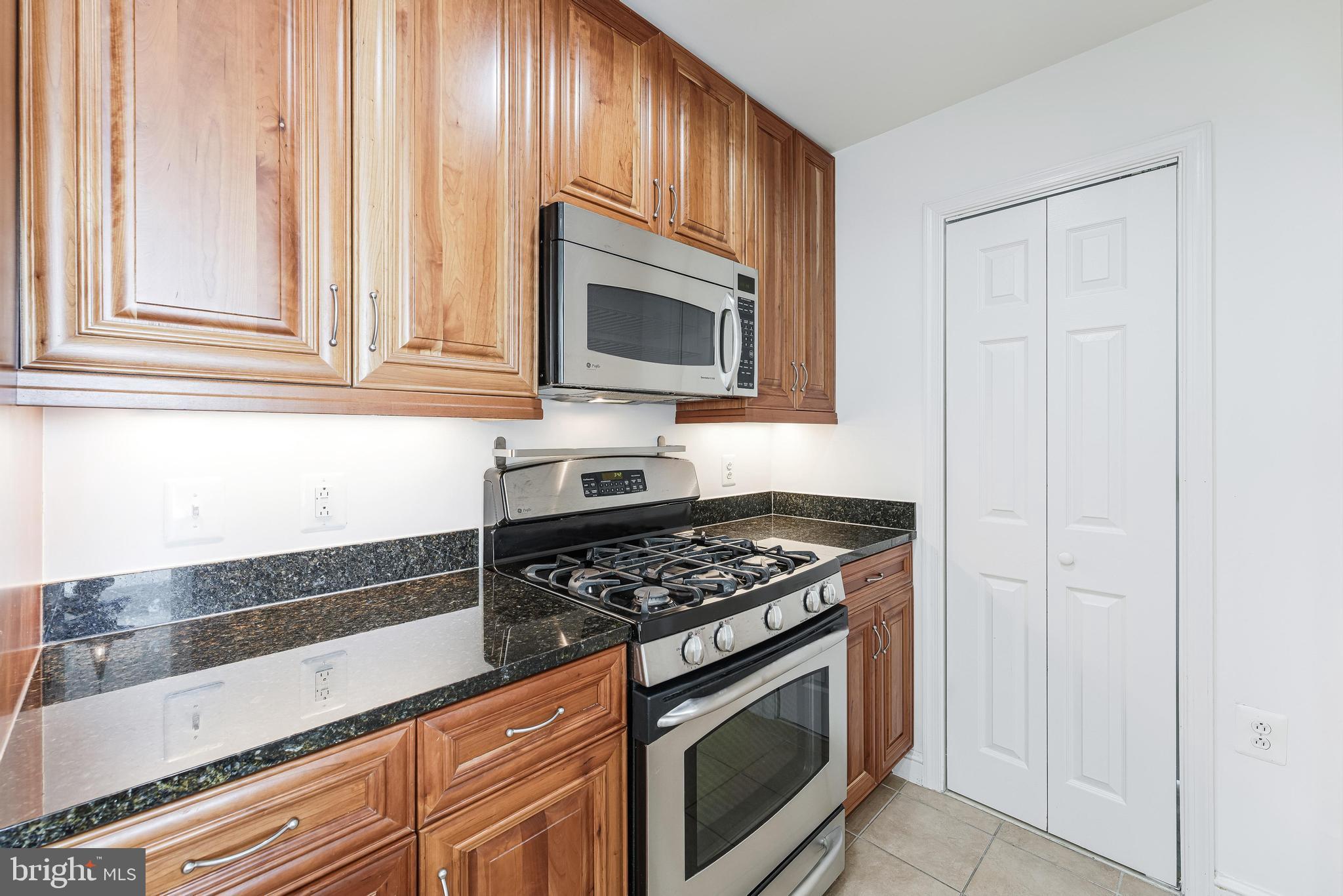 11990 Market Street, Unit 1414 Reston, VA 20190 - Photo 22 of 65 a kitchen with granite countertop cabinets stainless steel appliances and a window