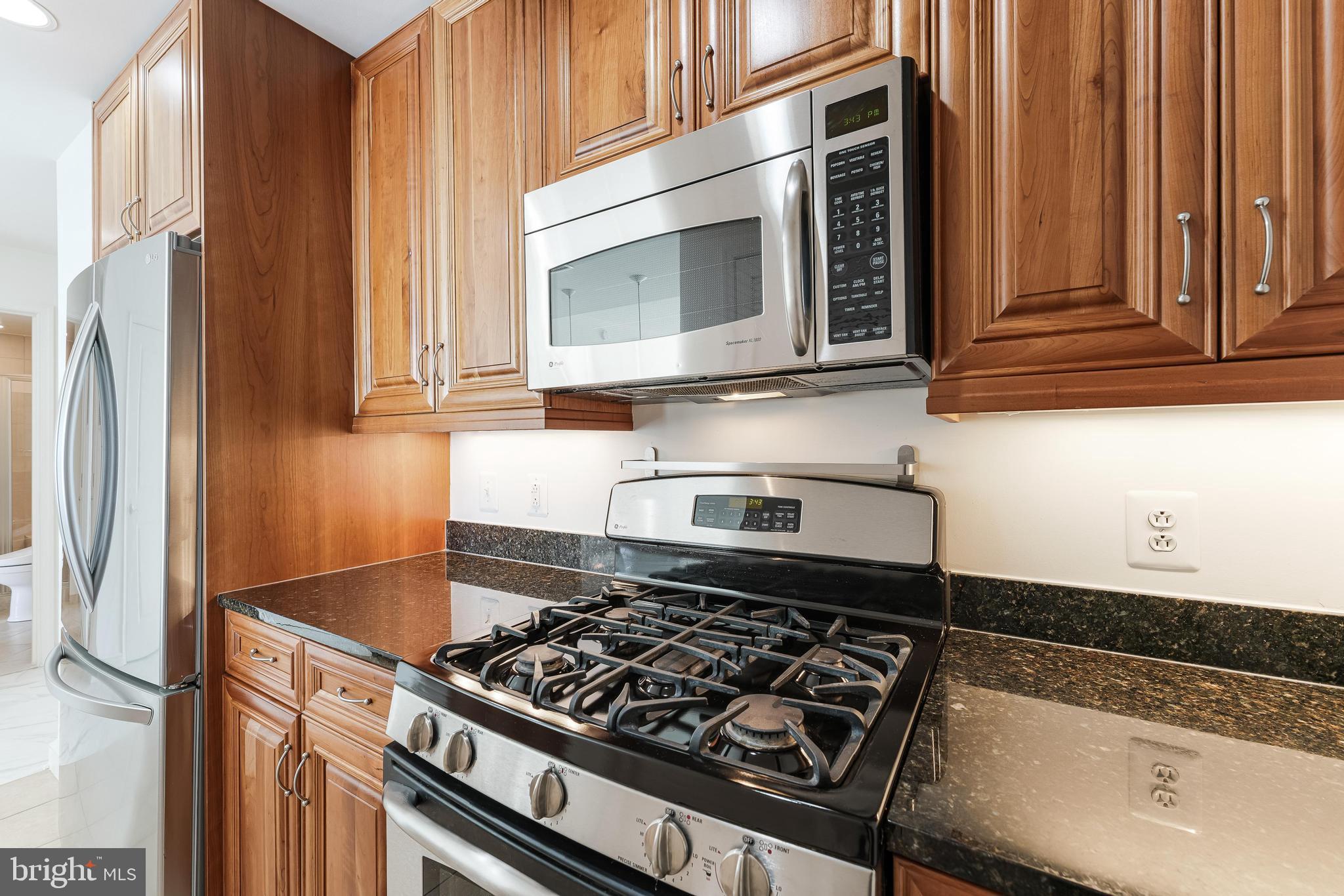 11990 Market Street, Unit 1414 Reston, VA 20190 - Photo 25 of 65 a kitchen with granite countertop a stove and a sink