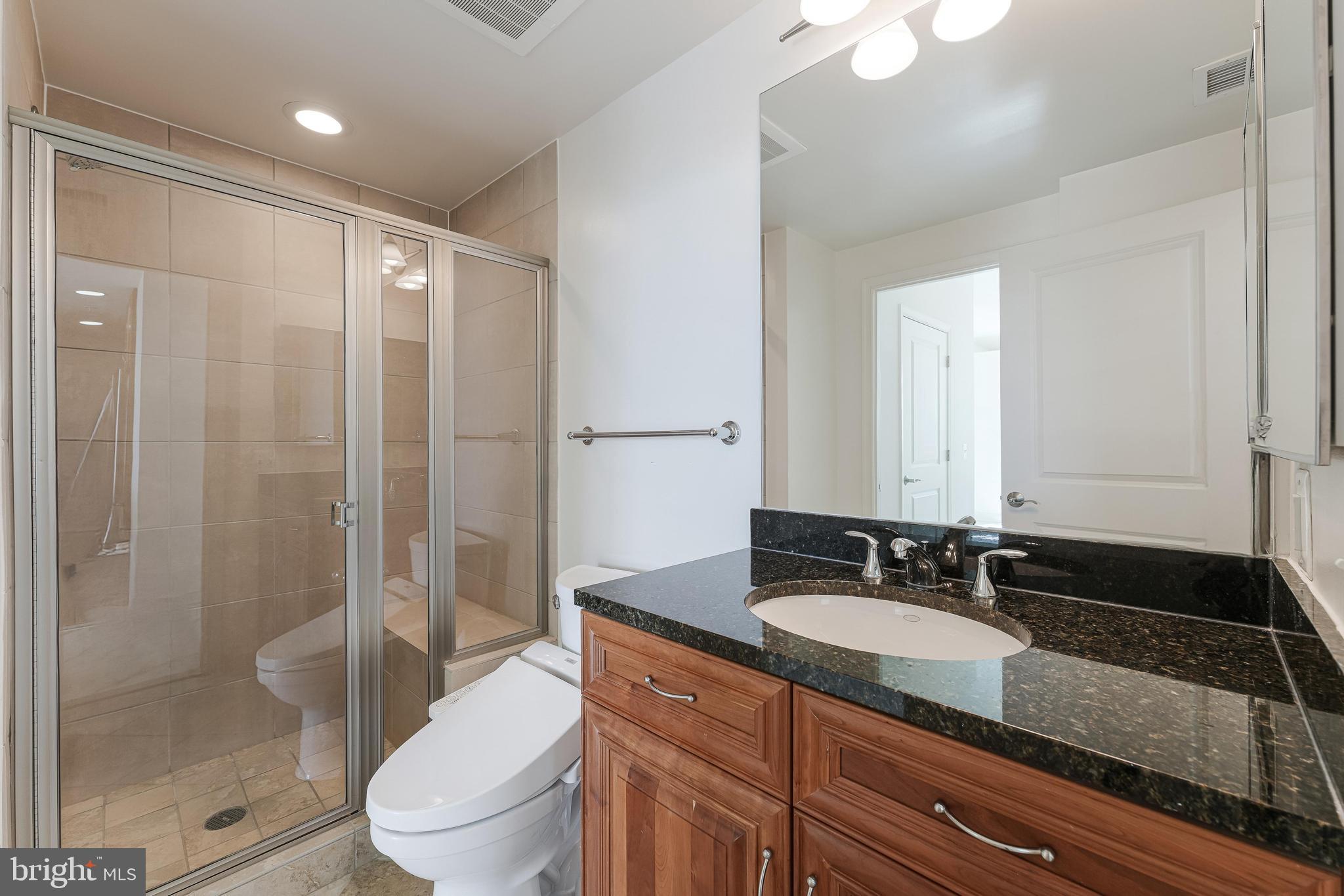 11990 Market Street, Unit 1414 Reston, VA 20190 - Photo 29 of 65 a bathroom with a granite countertop sink toilet and shower