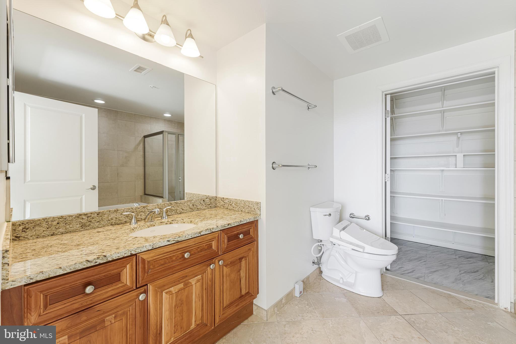 11990 Market Street, Unit 1414 Reston, VA 20190 - Photo 41 of 65 a spacious bathroom with a granite countertop sink toilet and shower