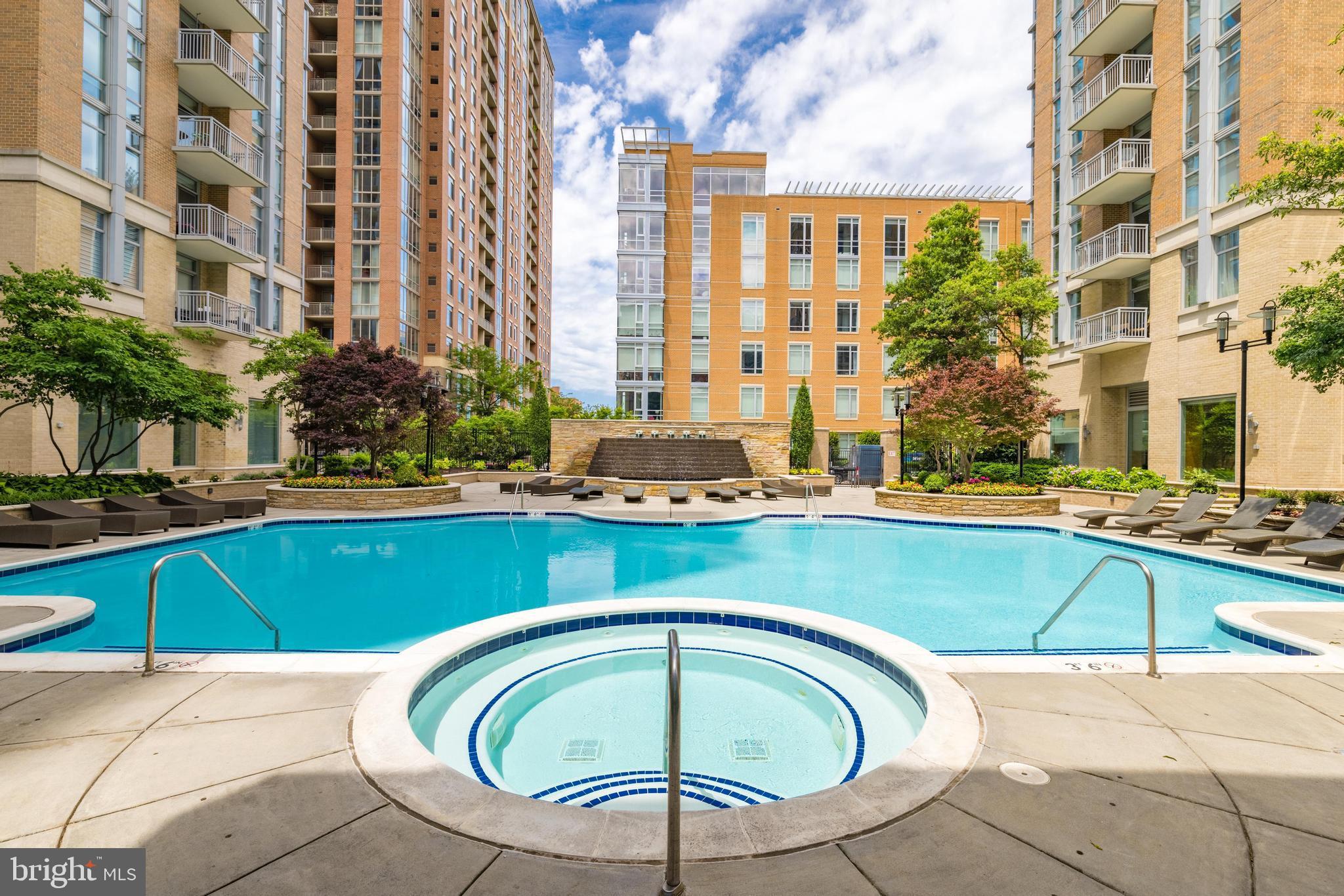 11990 Market Street, Unit 1414 Reston, VA 20190 - Photo 60 of 65 a swimming pool with outdoor seating and a tub