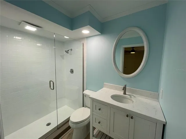 a bathroom with a double vanity sink toilet mirror and shower
