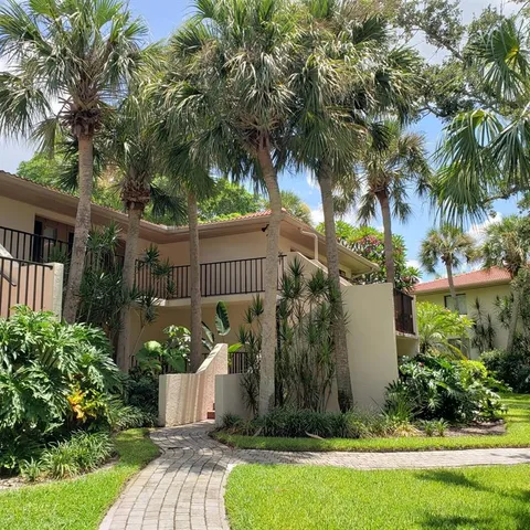 a view of a house with a yard and potted plants