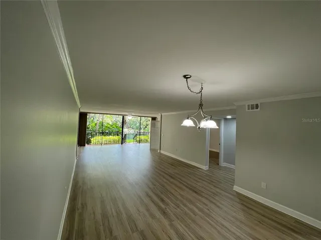 a view of a room with wooden floor fan and window