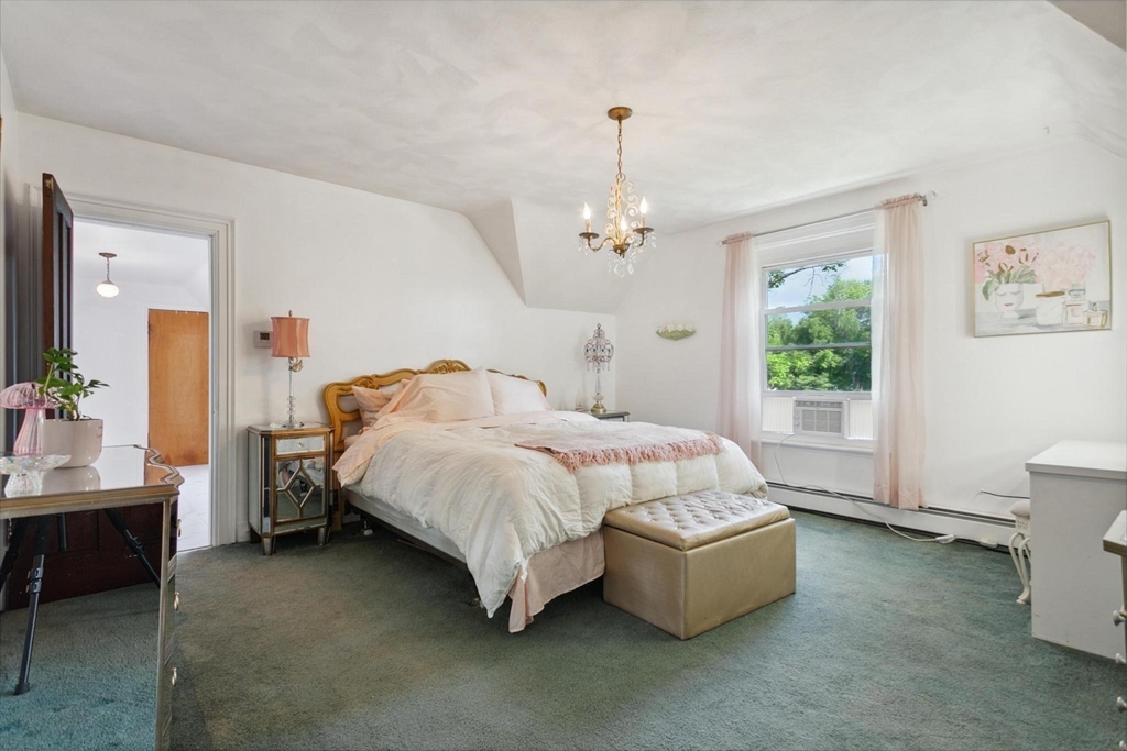 7 Spring Street Spencer, MA 01562 - Photo 23 of 38 a spacious bedroom with a bed table chair chandelier and a window