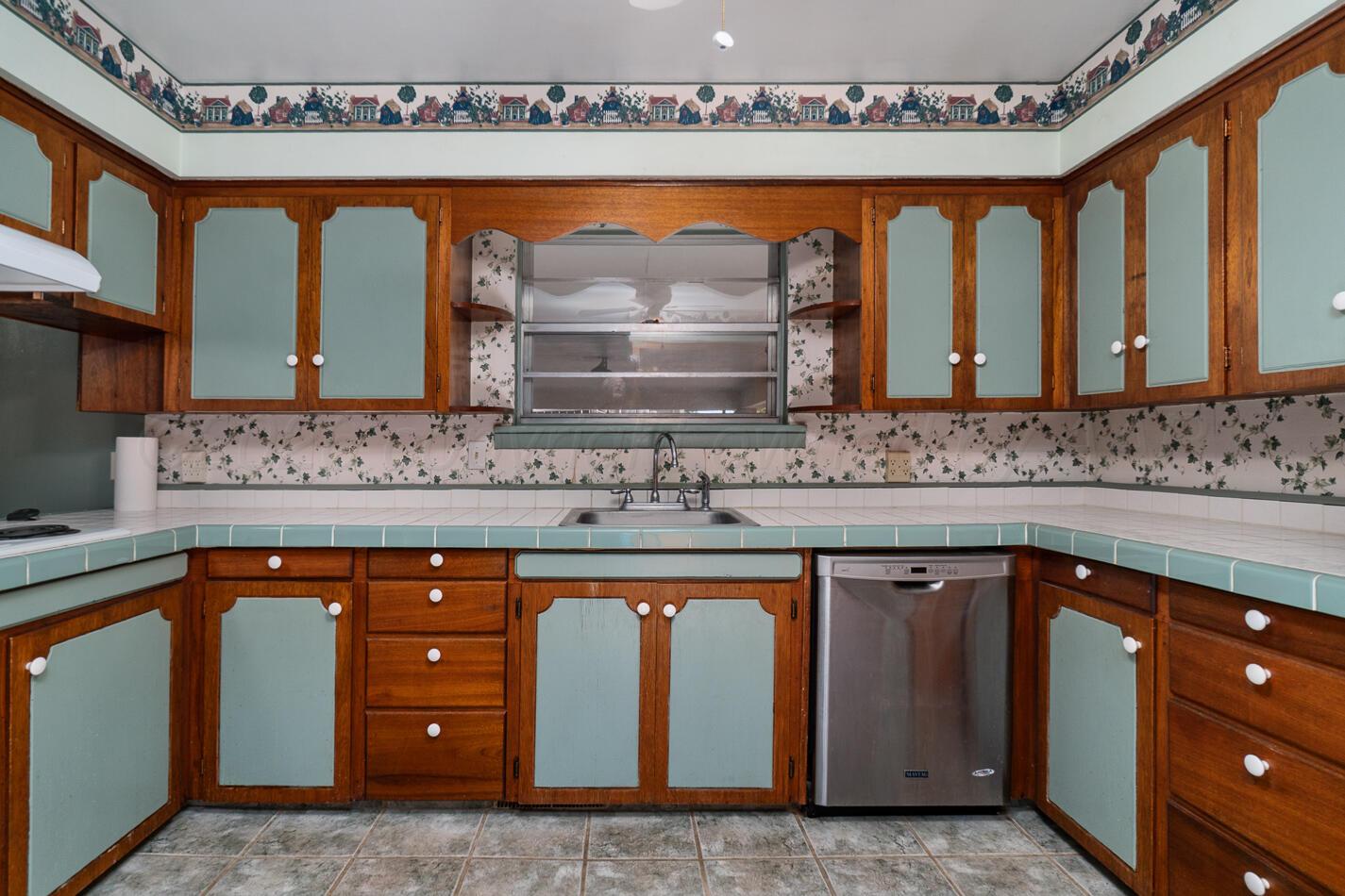 300 Mccarthy Street Borger, TX 79007 - Photo 8 of 31 a kitchen with a sink and a wooden cabinets