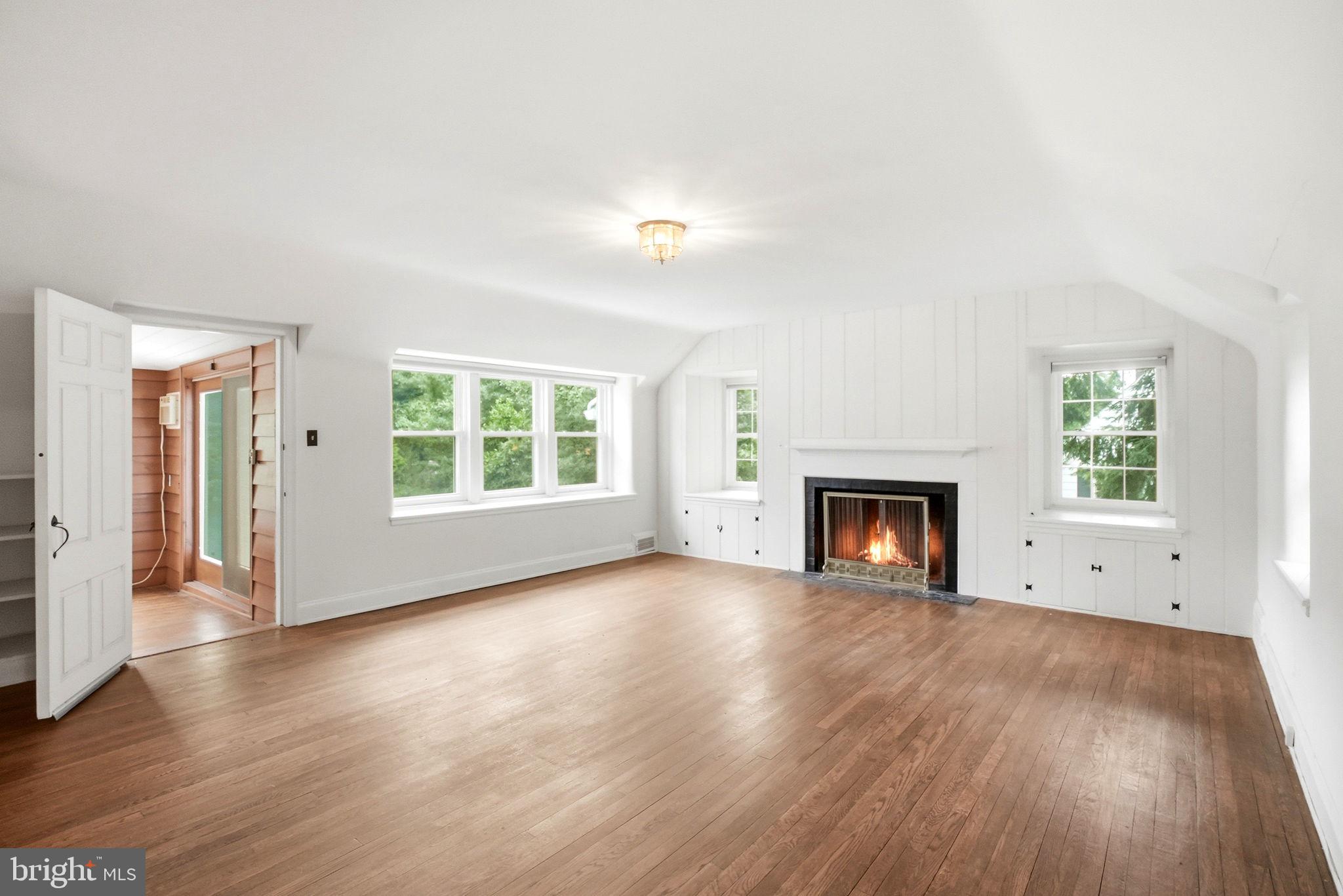 419 Riverview Road Swarthmore, PA 19081 - Photo 30 of 70 an empty room with wooden floor fireplace and windows