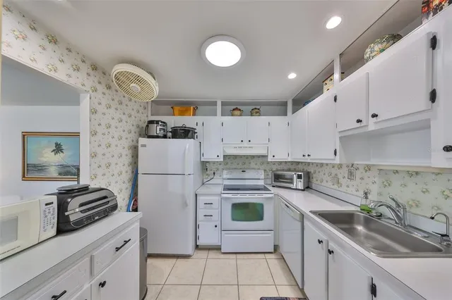 a kitchen with white cabinets and white appliances