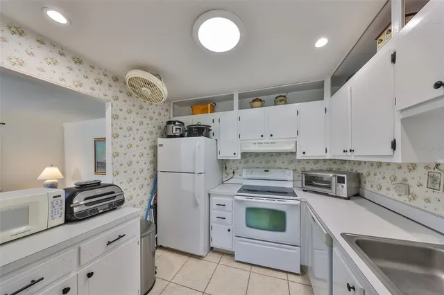 a dining room with wooden floor a chandelier a wooden table and chairs