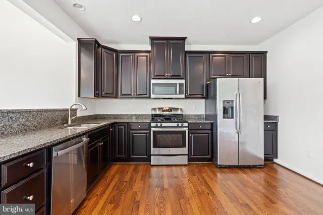 a kitchen with wooden cabinets and stainless steel appliances