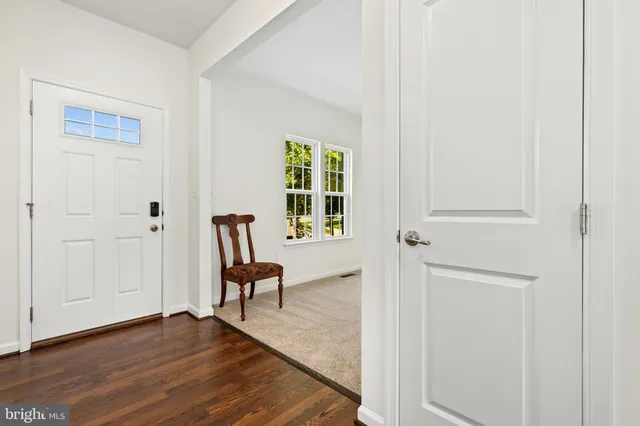 a view of a hallway with wooden floor and furniture