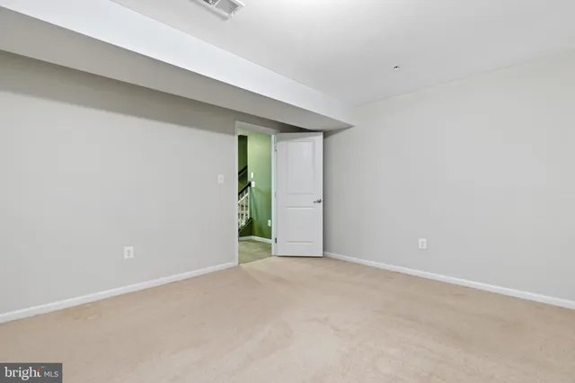a view of an empty room with stairs and furniture